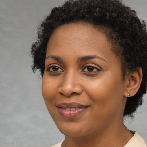 Joyful black young-adult female with short  brown hair and brown eyes