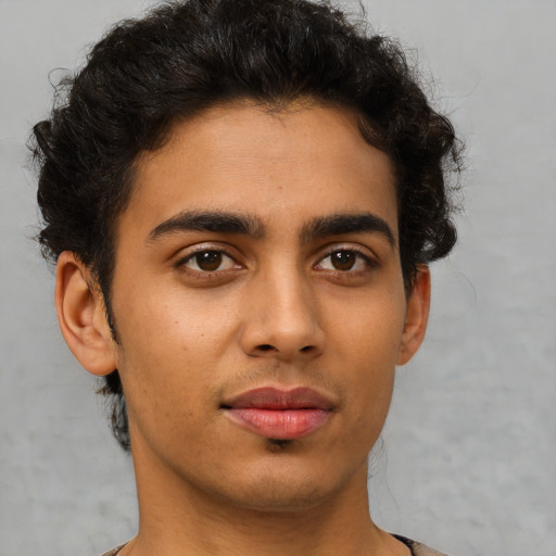 Joyful latino young-adult male with short  brown hair and brown eyes