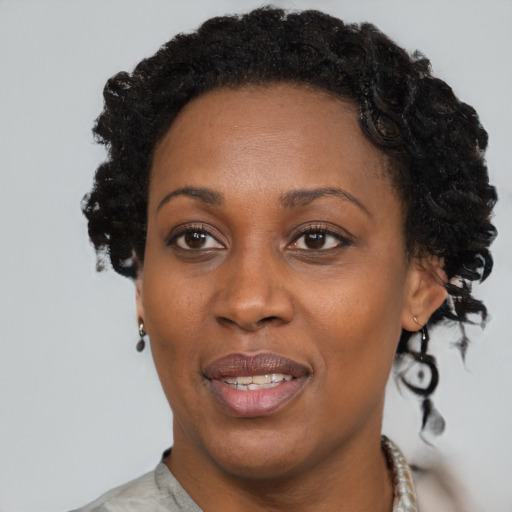 Joyful black adult female with short  brown hair and brown eyes