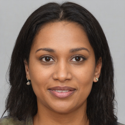 Joyful black young-adult female with long  brown hair and brown eyes