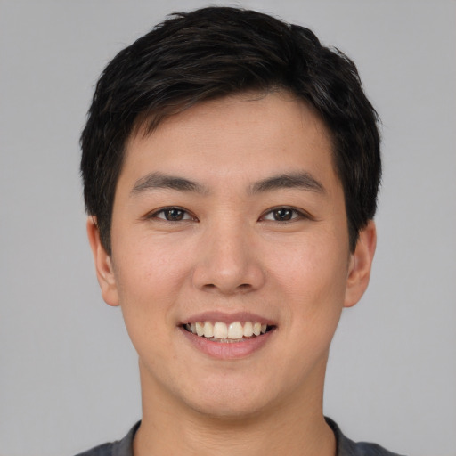 Joyful asian young-adult male with short  brown hair and brown eyes