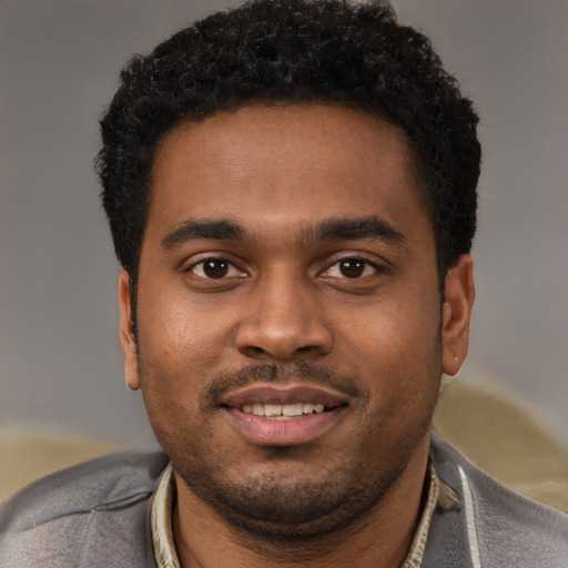 Joyful black young-adult male with short  black hair and brown eyes