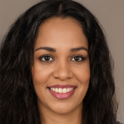 Joyful latino young-adult female with long  brown hair and brown eyes