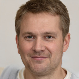 Joyful white adult male with short  brown hair and brown eyes