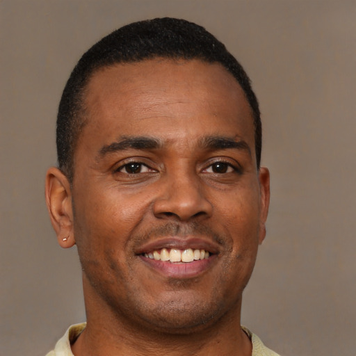 Joyful black young-adult male with short  brown hair and brown eyes