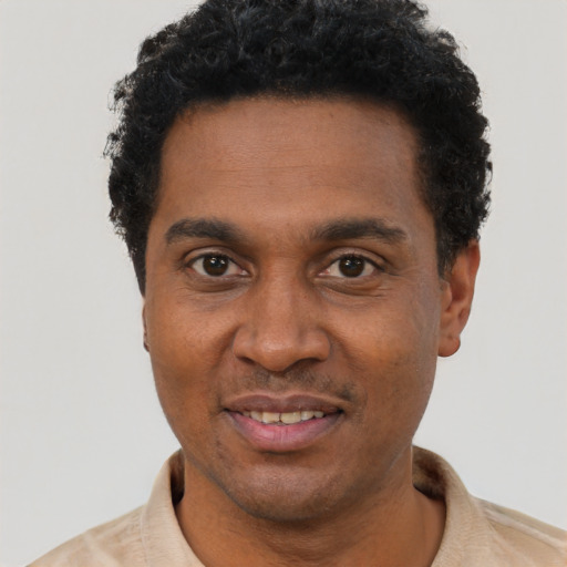 Joyful black adult male with short  black hair and brown eyes