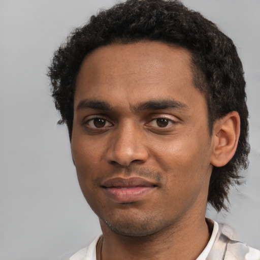 Joyful black young-adult male with short  black hair and brown eyes