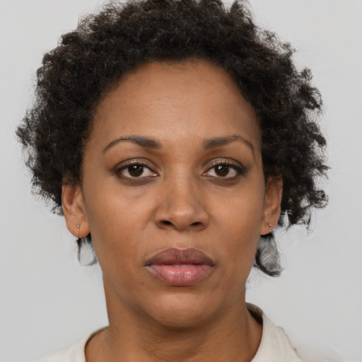 Joyful black adult female with short  brown hair and brown eyes