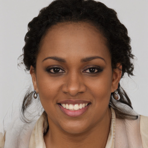 Joyful black young-adult female with long  brown hair and brown eyes