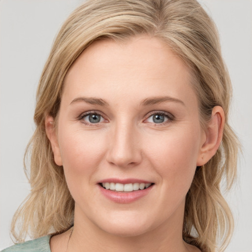 Joyful white young-adult female with medium  brown hair and blue eyes