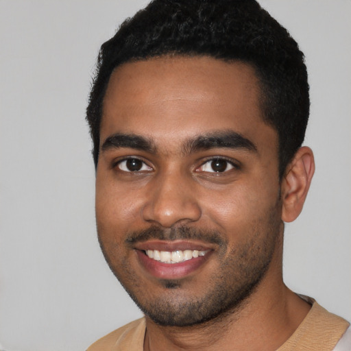 Joyful black young-adult male with short  black hair and brown eyes