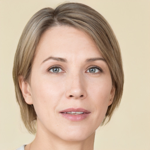 Joyful white adult female with medium  brown hair and green eyes