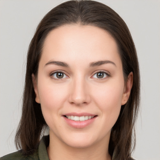 Joyful white young-adult female with long  brown hair and brown eyes