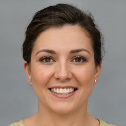 Joyful white young-adult female with short  brown hair and grey eyes