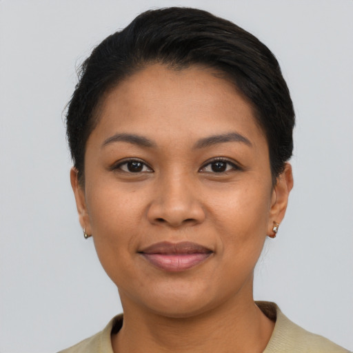 Joyful latino young-adult female with short  black hair and brown eyes