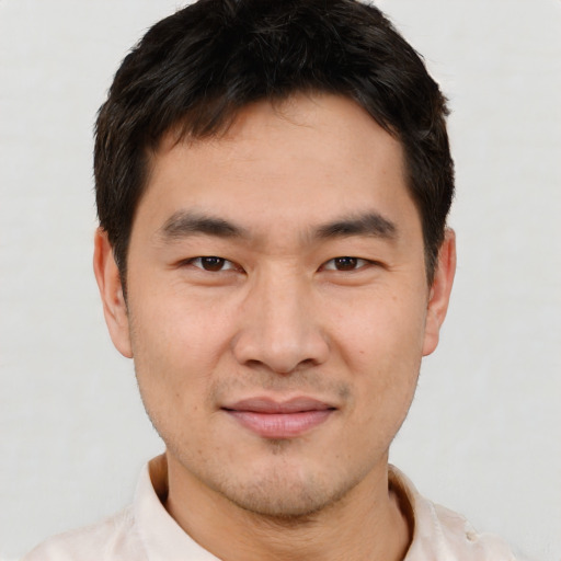 Joyful asian young-adult male with short  brown hair and brown eyes