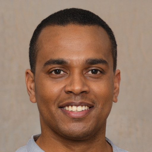 Joyful latino young-adult male with short  brown hair and brown eyes