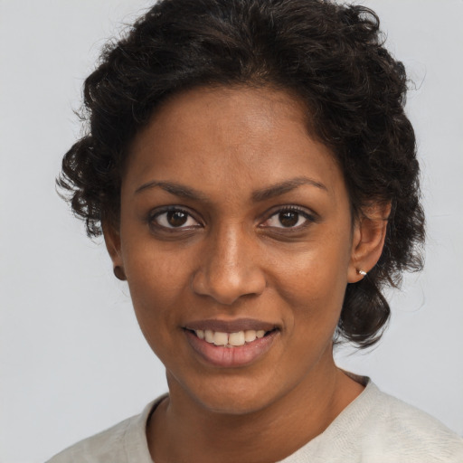 Joyful black adult female with medium  brown hair and brown eyes
