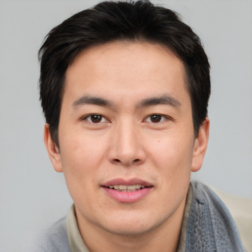 Joyful asian young-adult male with short  brown hair and brown eyes