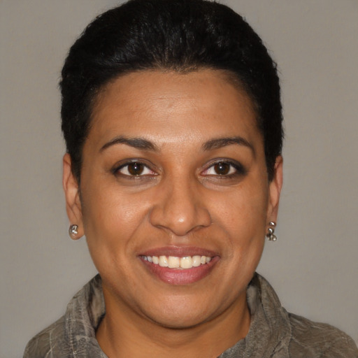 Joyful latino young-adult female with short  black hair and brown eyes