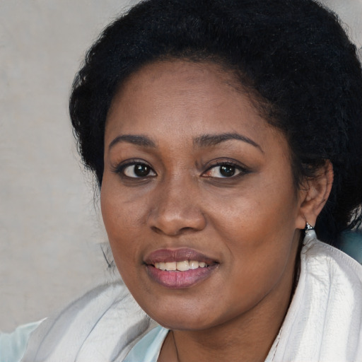 Joyful black young-adult female with short  black hair and brown eyes