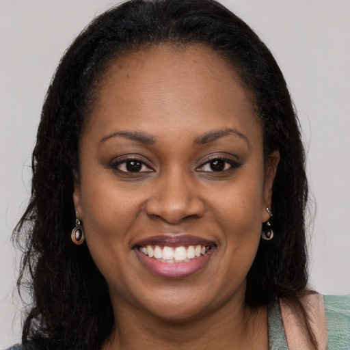 Joyful black young-adult female with long  brown hair and brown eyes