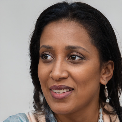 Joyful black adult female with long  brown hair and brown eyes