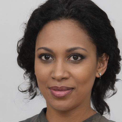 Joyful black young-adult female with medium  brown hair and brown eyes