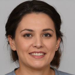 Joyful white adult female with medium  brown hair and brown eyes