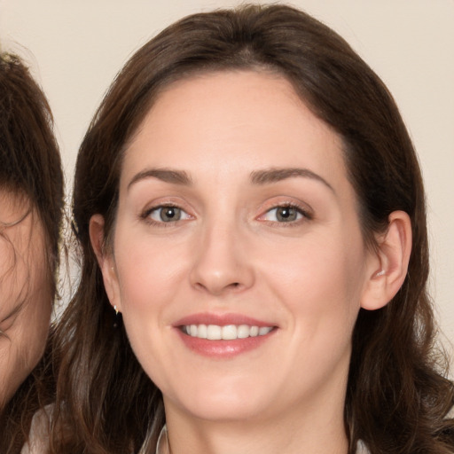 Joyful white young-adult female with long  brown hair and brown eyes