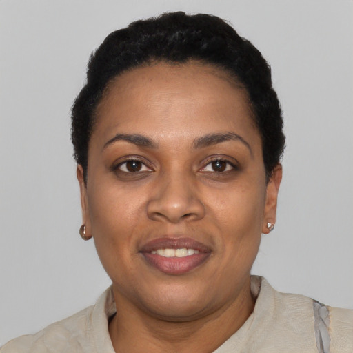 Joyful black young-adult female with short  black hair and brown eyes