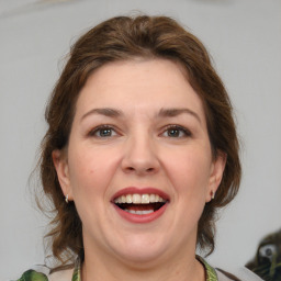 Joyful white adult female with medium  brown hair and green eyes