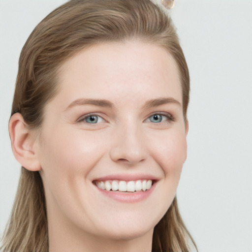 Joyful white young-adult female with long  brown hair and blue eyes