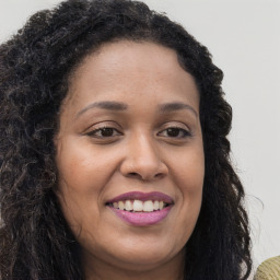 Joyful black young-adult female with long  brown hair and brown eyes