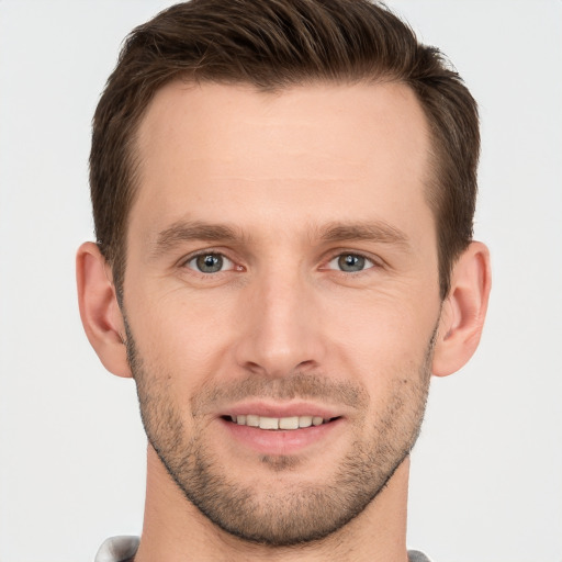 Joyful white young-adult male with short  brown hair and grey eyes