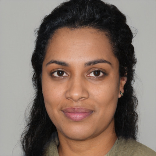 Joyful black young-adult female with long  black hair and brown eyes
