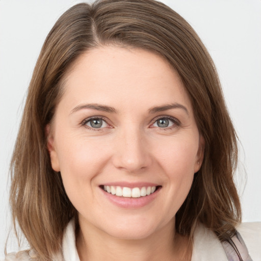 Joyful white young-adult female with medium  brown hair and grey eyes