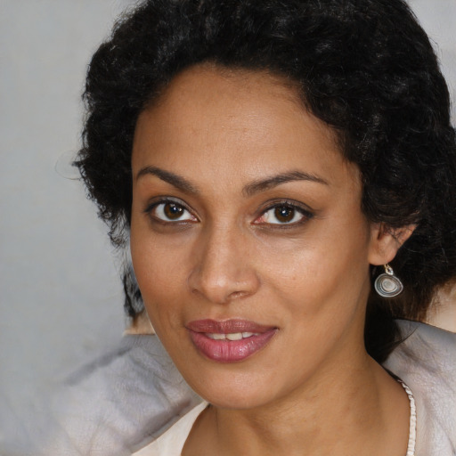 Joyful black young-adult female with long  brown hair and brown eyes