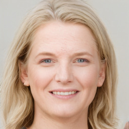 Joyful white young-adult female with long  brown hair and blue eyes