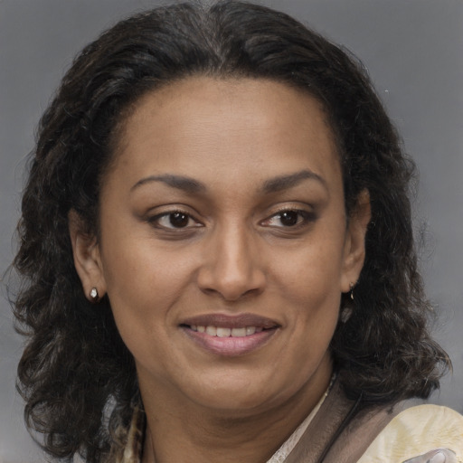 Joyful black adult female with long  brown hair and brown eyes