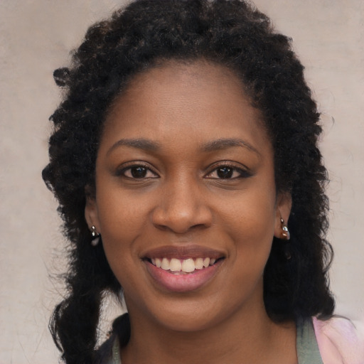 Joyful black young-adult female with long  black hair and brown eyes