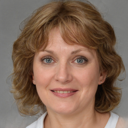 Joyful white adult female with medium  brown hair and blue eyes