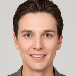 Joyful white young-adult male with short  brown hair and grey eyes