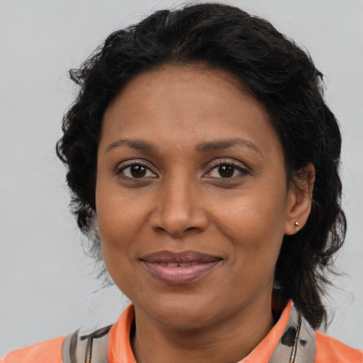 Joyful latino adult female with medium  brown hair and brown eyes