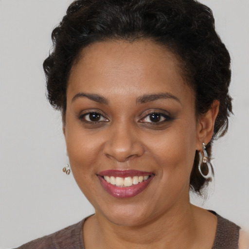 Joyful black young-adult female with medium  brown hair and brown eyes