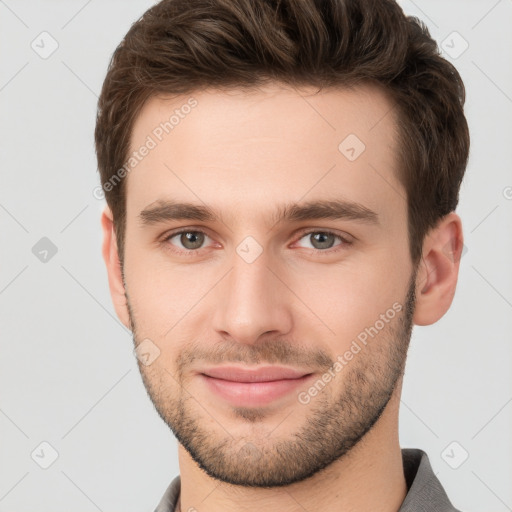 Joyful white young-adult male with short  brown hair and grey eyes