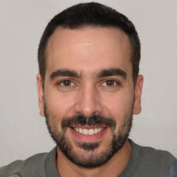 Joyful white young-adult male with short  black hair and brown eyes