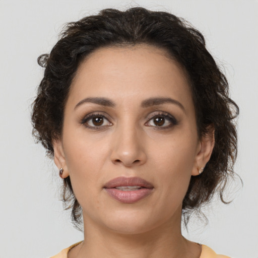 Joyful latino young-adult female with medium  brown hair and brown eyes