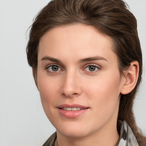 Joyful white young-adult female with medium  brown hair and grey eyes