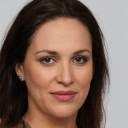 Joyful white adult female with long  brown hair and brown eyes